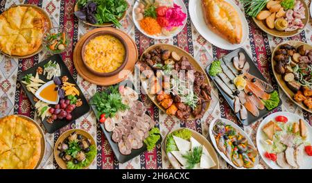 plats nationaux géorgiens et azerbaïdjanais khachapuri cuit au suluguni, champignons et légumes et herbes avec une assiette de fromages et s assortis Banque D'Images