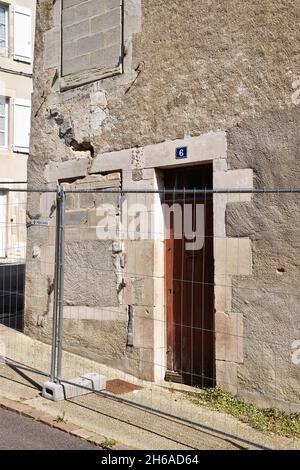 Le coin d'une importante maison de trois étages à Montmorillon, en France, qui commence à s'effondrer, des fissures majeures et des fenêtres pleines pour la raidir Banque D'Images