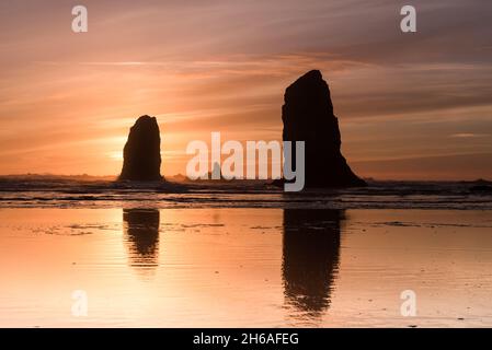 Coucher de soleil pâle derrière les aiguilles à Cannon Beach Banque D'Images