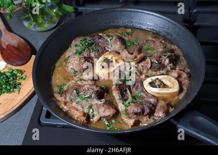 Steak de veau braisé Ossobuco alla milanais avec des herbes dans une casserole.Cuisine italienne.Gros plan. Banque D'Images