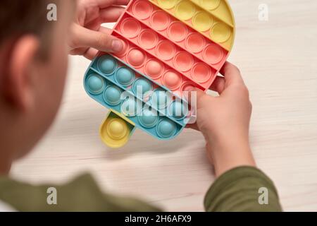 Les mains des enfants poussent la pop sensorielle.Jouets antistress colorés, simple creux, tube pop.Rainbow silicone Sensory fidget Nouveau populaire jouet en silicone tendance. Banque D'Images
