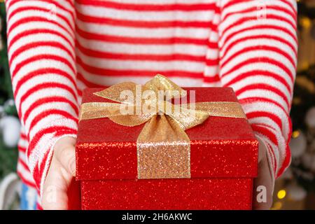 Jeune femme méconnaissable tenant une boîte cadeau rouge. Banque D'Images