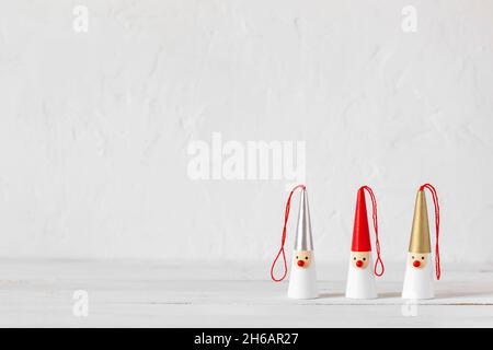 Trois figurines de Santa Clasections sur fond de bois blanc, vue latérale, espace de copie Banque D'Images