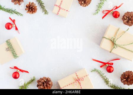 Composition de Noël composée de boîtes-cadeaux, branches d'arbre du nouvel an, cônes, balles décoratives, forme de cadre, vue du dessus Banque D'Images
