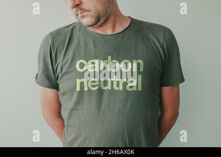 Homme portant un t-shirt vert avec texte neutre en carbone, portrait d'écologiste et activiste environnemental Banque D'Images