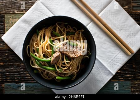 Ramen avec du bœuf et des nouilles aux œufs dans des bols sur fond de bois Banque D'Images