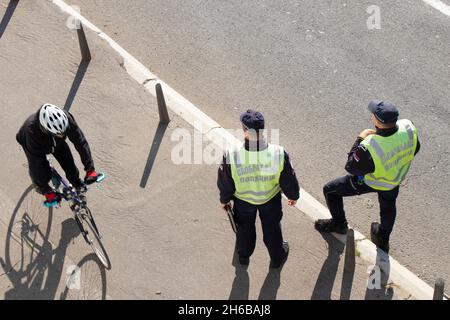 Belgrade, Serbie - 25 octobre 2021 : deux policiers de la circulation en service dans la rue de la ville et un cycliste en mouvement flou, vue arrière grand angle Banque D'Images