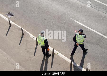 Belgrade, Serbie - 25 octobre 2021 : deux policiers de la circulation en service, arrêtant des véhicules pour le contrôle, dans la vue arrière à angle élevé Banque D'Images