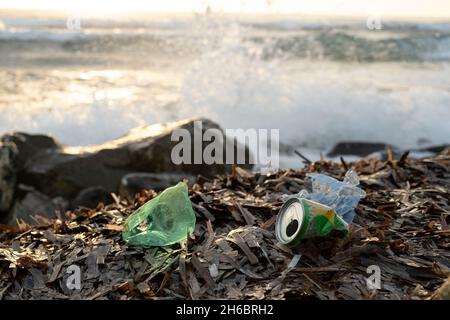 Bouteille en plastique et déchets d'aluminium sur la côte océanique, pollution par les débris environnementaux Banque D'Images