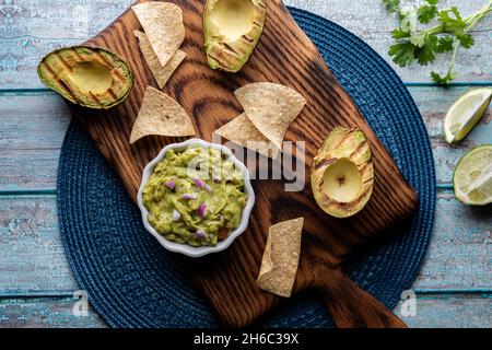 Vue de haut en bas d'un bol de guacamole maison entouré de chips tortilla Banque D'Images