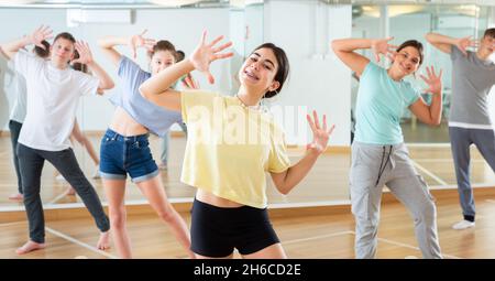 Une adolescente s'exerçant pendant un cours de danse de groupe Banque D'Images