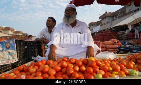 Image haute résolution : tomate et tomate Vendeur sur un marché indien dynamique #tomate ,tomatoseller, #india, #Vegetablemarket Banque D'Images