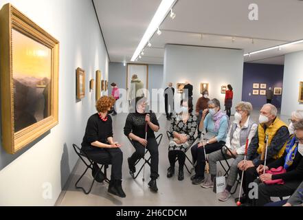 Leipzig, Allemagne.14 novembre 2021.Au Musée des Beaux-Arts, les aveugles, malvoyants et leurs compagnons s'assoient dans l'exposition 'Caspar David Friedrich et les romantiques de Düsseldorf' lors d'un entretien artistique avec Carolin Rothmund (l), responsable de l'éducation artistique, et le co-modérateur aveugle Sebastian Schulze (2e à partir de la gauche).Le musée propose des conférences d'art spéciales sur son exposition pour les personnes avec et sans déficience visuelle.Les participants s'occupent intensivement de la visualisation des œuvres d'art.Credit: Waltraud Grubitzsch/dpa-Zentralbild/dpa/Alay Live News Banque D'Images