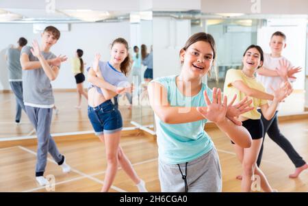 Une adolescente s'exerçant pendant un cours de danse de groupe Banque D'Images