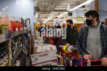 New York, États-Unis.14 novembre 2021.Les gens font la queue pour faire la queue dans une épicerie à New York, aux États-Unis, le 14 novembre 2021.L'indice des prix à la consommation d'octobre, qui mesure un panier de marchandises, a grimpé de 6.2 pour cent par rapport au même mois l'an dernier, et se situe maintenant à un sommet de 30 ans.Le coût des aliments de base -- la viande, les œufs, le poisson et la volaille -- a grimpé de 10.5 pour cent pour l'exercice terminé le 2021 septembre, a indiqué le Bureau des statistiques du travail.Crédit : Wang Ying/Xinhua/Alay Live News Banque D'Images