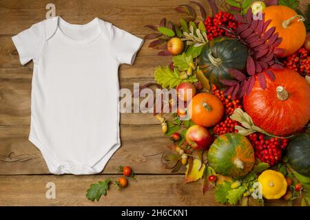 Combinaison à manches courtes en coton blanc avec pommes, citrouilles et feuilles d'automne.Modèle de combinaison neutre pour le sexe, avec imprimé barboteuse nouveau-né Banque D'Images