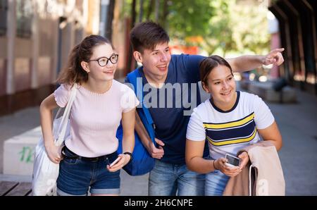 Adolescent souligne quelque chose d'intéressant pour deux amies Banque D'Images