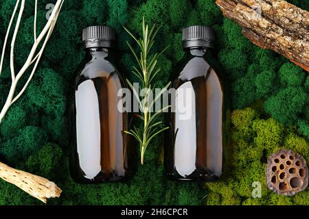 Ensemble de bouteilles de verre brun produits de beauté sur fond de mousse Banque D'Images