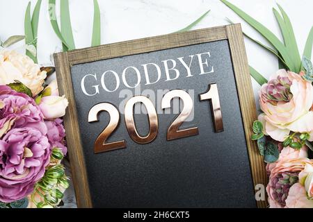 Au revoir 2021 texte sur tableau noir avec décoration florale sur fond de marbre Banque D'Images