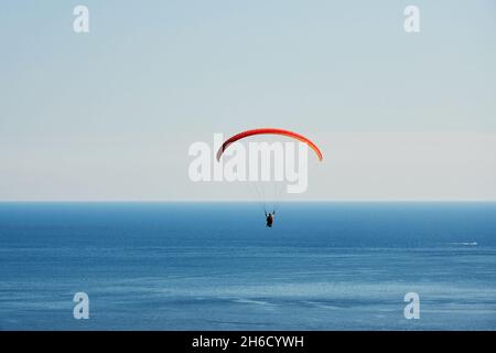 Les parapentes s'envolent dans le ciel au-dessus de la mer bleu profond.Sports extrêmes et activités de loisirs en vacances Banque D'Images