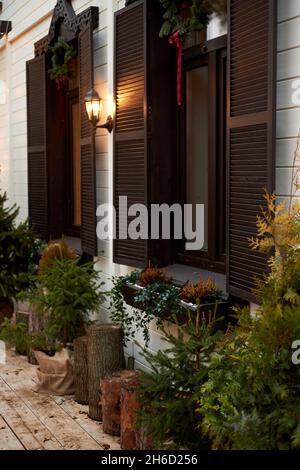 Fenêtres avec volets en bois sombre et verdure décorative. Chalet. Banque D'Images