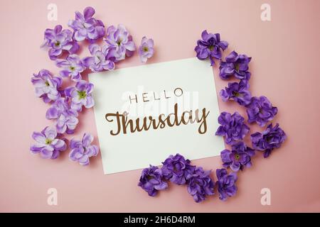 Texte typographique carte Hello Thursday avec bouquet de fleurs sur fond rose Banque D'Images