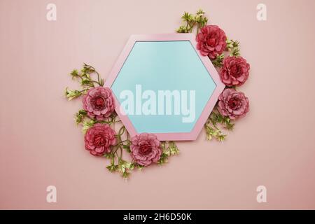 Fond bleu Hexagon et bordure rose décorent avec des fleurs sur fond rose Banque D'Images