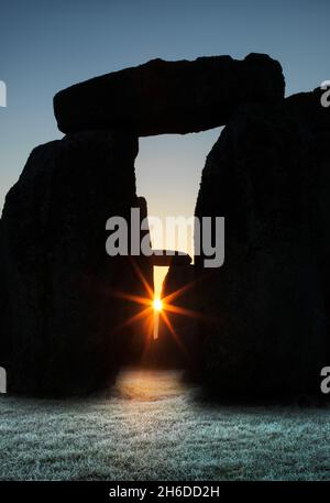 Vue générale de Stonehenge, montrant les rayons du soleil levant qui se branle à travers les ouvertures dans les triléthons, 2012. Banque D'Images