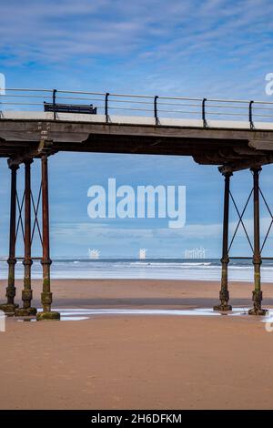 Les éoliennes de Redcar à travers les supports en fer de Saltburn Pier, North Yorkshire, Angleterre Banque D'Images