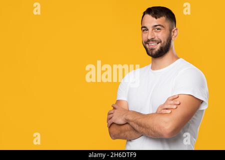 Gai amical confiant et confiant, homme caucasien mature, en t-shirt blanc avec bras croisés sur la poitrine Banque D'Images