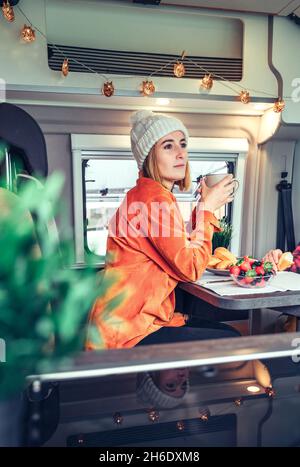 Femme prenant le petit déjeuner dans une camionnette de camping Banque D'Images