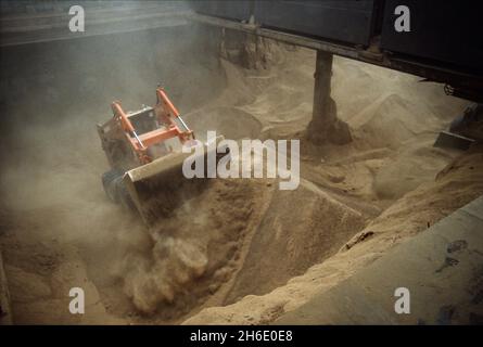 Alimentez les céréales déchargées à l'aide d'un chargeur frontal monté sur roues dans le port de Hambourg. Banque D'Images