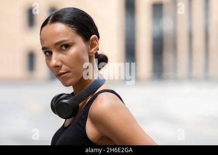 Gros plan Portrait de jeune athlète féminin sérieux posant à l'extérieur pendant l'entraînement Banque D'Images