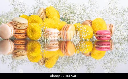 Macarons colorés et belle composition de fleurs sur fond blanc de vacances.Photo de haute qualité Banque D'Images