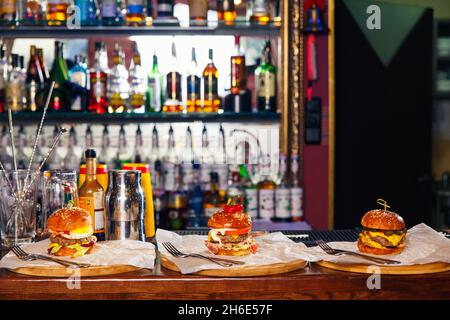 Trois hamburgers frais différents sur papier sur le bar tendre Banque D'Images