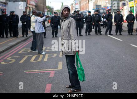 Les séquelles de ce matin des dernières nuits s'émeute sur Tottenham High Road dans le nord de Londres.L'émeute a été déclenchée après que la police a abattu Mark Duggan, 29 ans, jeudi.La photo montre: Une jeune femme regardant la dévastation laissée par les émeutiers. Banque D'Images