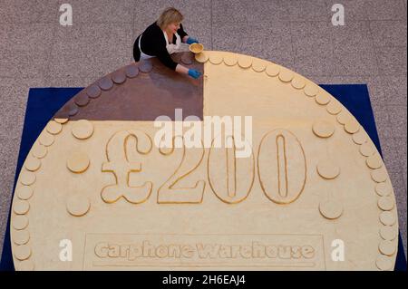 Le Carphone Warehouse dévoile la plus grande pièce de chocolat au monde au centre commercial Westfield de Londres.Un nouveau record Guinness World a été établi avec la pièce de monnaie pesant 276 kg, pour lancer les bons cadeaux gratuits de 200 £ de l'entrepôt carphone avec les nouveaux mobiles.Le record mondial guinness de la plus grande pièce n'a été établi que le 17 novembre 2011 à 265 kg pour marquer l'ouverture d'un nouveau centre commercial.La pièce est l'équivalent de 5,345 barres de chocolat. Banque D'Images