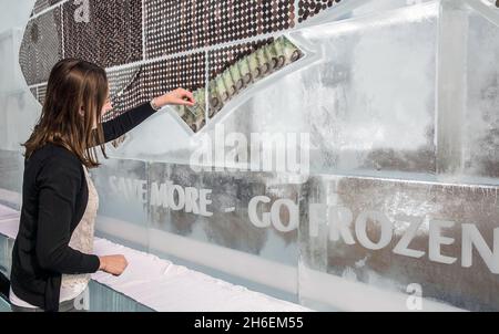 Aujourd'hui, un panneau d'affichage gelé de 20 pieds entièrement constitué de glace et d'argent liquide a été dévoilé pour inciter Brits à économiser de l'argent et à réduire les déchets ménagers en utilisant davantage leur congélateur.Le panneau d'affichage contenant à‚Â £ 700 en pièces et billets (la quantité moyenne de déchets ménagers chaque année sur la nourriture) a été créé par iFreeze, iSave et suit la recherche révélant que deux millions de Britanniques conservent l'argent dans le congélateur mais jettent 850,000 tonnes de bonne nourriture chaque année. Banque D'Images