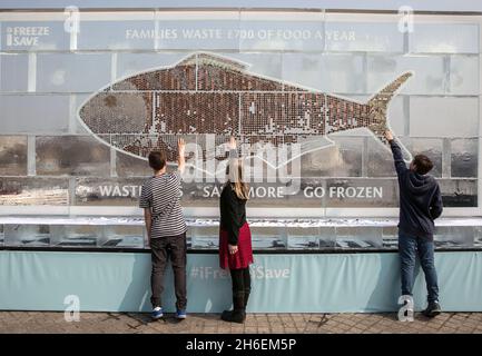 Aujourd'hui, un panneau d'affichage gelé de 20 pieds entièrement constitué de glace et d'argent liquide a été dévoilé pour inciter Brits à économiser de l'argent et à réduire les déchets ménagers en utilisant davantage leur congélateur.Le panneau d'affichage contenant à‚Â £ 700 en pièces et billets (la quantité moyenne de déchets ménagers chaque année sur la nourriture) a été créé par iFreeze, iSave et suit la recherche révélant que deux millions de Britanniques conservent l'argent dans le congélateur mais jettent 850,000 tonnes de bonne nourriture chaque année. Banque D'Images