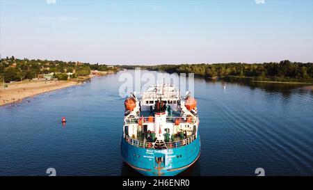 Cargo se tenant à la plage.Vidéo.Vue de dessus du magnifique vieux cargo sur la rivière.Le cargo se tient à la plage avec des gens en arrière-plan du village Banque D'Images