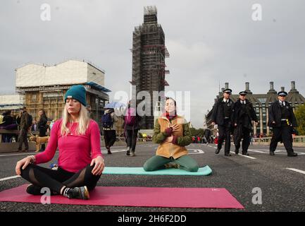 Extinction les activistes de la rébellion prennent part au Yoga alors qu'ils bloquent le pont de Westminster ce matin Banque D'Images