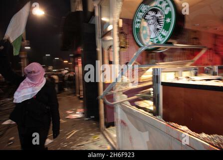 Les fenêtres d'une succursale de café Starbucks sont écrasées lors d'une manifestation contre le conflit à Gaza près de l'ambassade israélienne à Londres.Une manifestation pacifique a d'abord pris fin avec un groupe de manifestants face à la police anti-émeute montée qui lançait des missiles et fracassaient des fenêtres sur Kensington High Street, près de l'ambassade israélienne. Banque D'Images