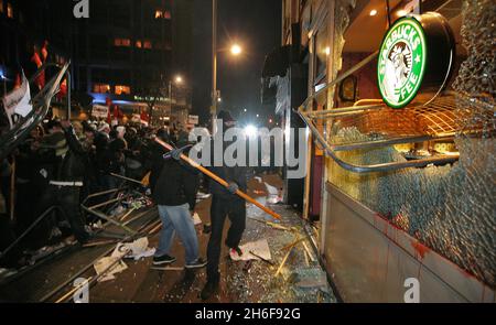 Les fenêtres d'une succursale de café Starbucks sont écrasées lors d'une manifestation contre le conflit à Gaza près de l'ambassade israélienne à Londres.Une manifestation pacifique a d'abord pris fin avec un groupe de manifestants face à la police anti-émeute montée qui lançait des missiles et fracassaient des fenêtres sur Kensington High Street, près de l'ambassade israélienne. Banque D'Images