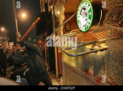 Les fenêtres d'une succursale de café Starbucks sont écrasées lors d'une manifestation contre le conflit à Gaza près de l'ambassade israélienne à Londres.Une manifestation pacifique a d'abord pris fin avec un groupe de manifestants face à la police anti-émeute montée qui lançait des missiles et fracassaient des fenêtres sur Kensington High Street, près de l'ambassade israélienne. Banque D'Images