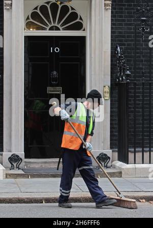 Un nettoyeur balaie l'extérieur de la No 10 avant que le PM Gordon Brown quitte Downing Street pour ses dernières questions du premier ministre à la Chambre des communes. Banque D'Images