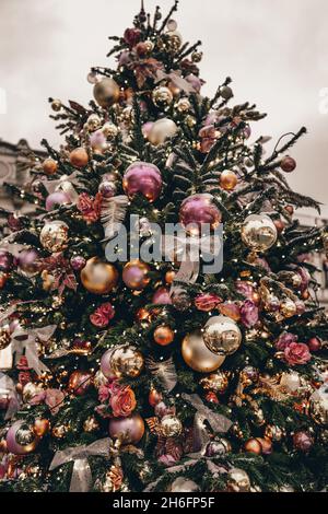 Arbre de Noël avec rubans et boules de Noël dans la rue de la ville festive Banque D'Images