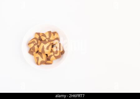 Biscuits bruns au chocolat en forme de carré servis dans une assiette blanche.Vue supérieure avec recouvrement en toile de fond blanche avec espace de copie pour le texte personnalisé Banque D'Images