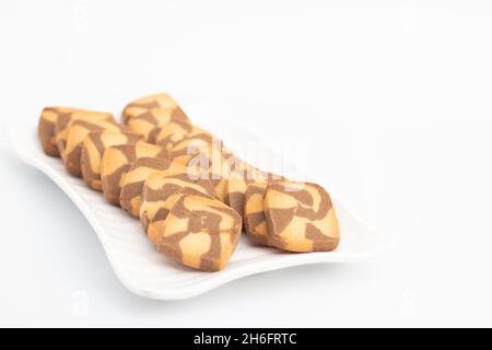 Petits gâteaux au chocolat en forme de carré servis dans un plateau blanc.Isolé sur fond blanc avec espace de copie pour le texte personnalisé.Vue de face gros plan et sélection Banque D'Images