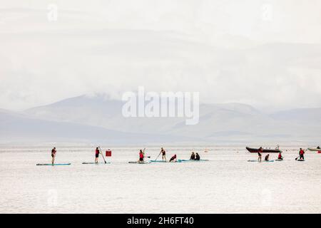 Levez les surfeurs sur les planches SUP au large de Old Head Beach, Louisburgh, County Mayo, Irlande Banque D'Images