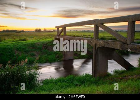 Pont sur la rivière Uherka et coucher de soleil, Czulczyce, Pologne Banque D'Images